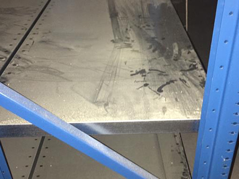 Dreckiges Regal in Lagerhalle vor Reinigung